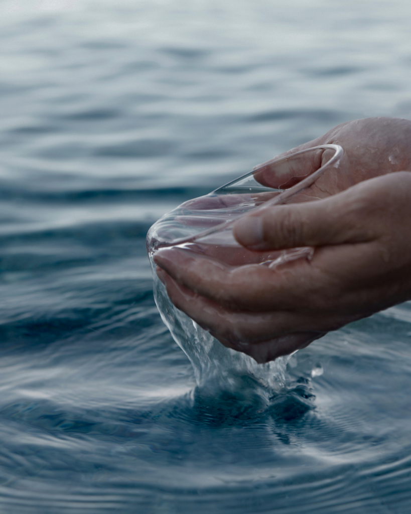 Des mains recueillent de l’eau, symbole du baptême chrétien