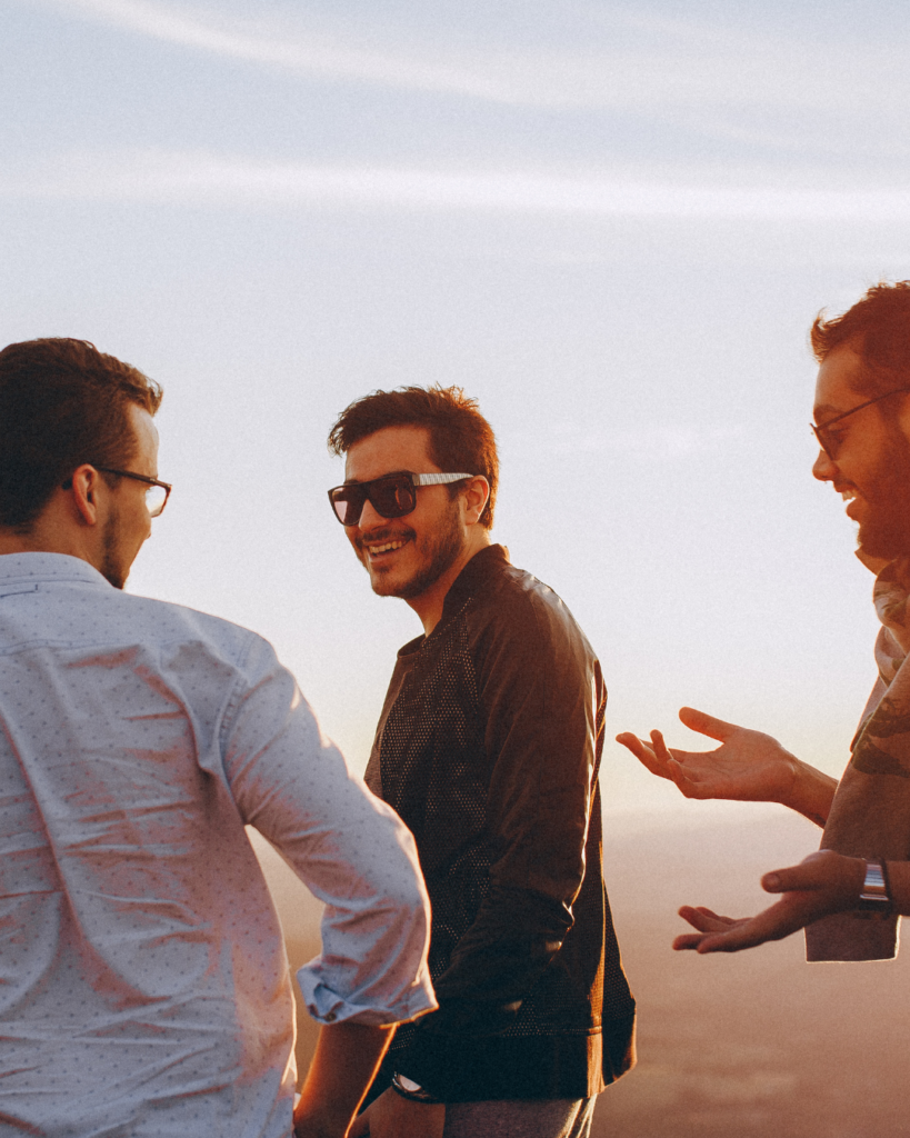 Trois hommes échangent dans une ambiance conviviale