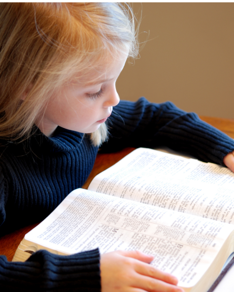 Une enfant lit une Bible ouverte